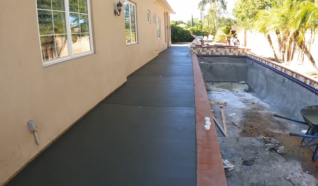 Concrete contractor finishing a walkway installation at a Surprise, AZ property